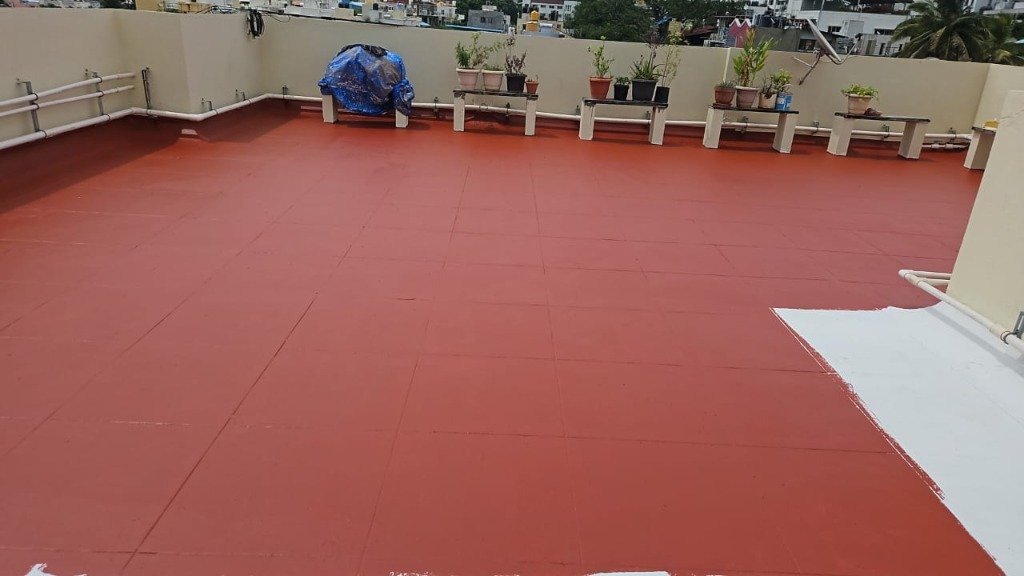 Waterproofed terrace surface with red protective layer and plant pots Bangalore